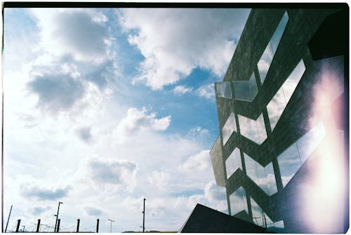 Free An Old Photo of White Clouds over Gray Building with Glass Stock Photo