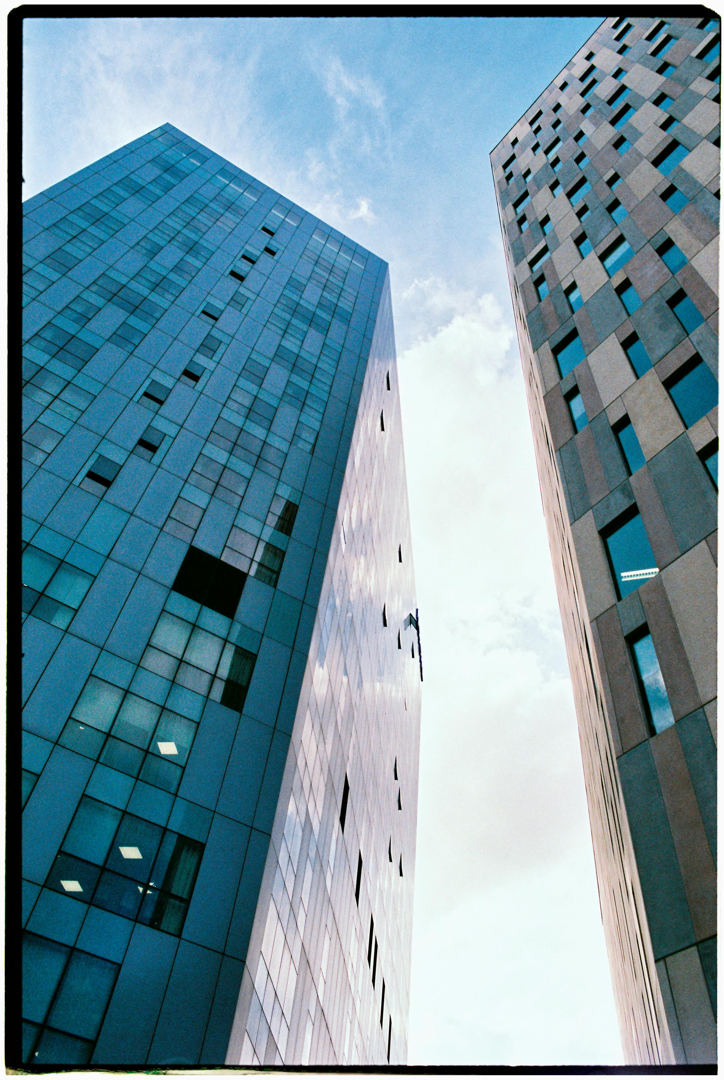 Low angle view of modern skyscrapers with glass facades against a clear blue sky.
