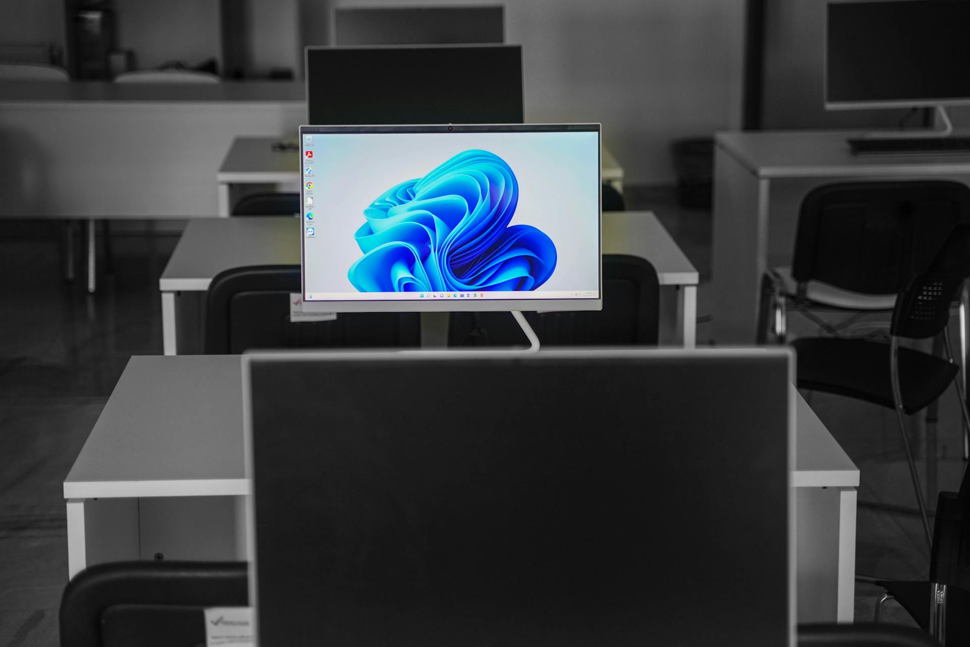 A contemporary office setup featuring computers on desks with modern flat screens.