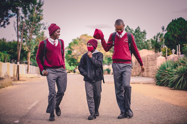 A Group Of Man In Uniform Walking Together On Asphalt Road