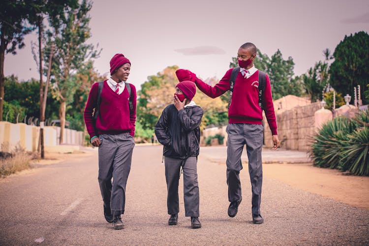 A Group Of Man In Uniform Walking Together On Asphalt Road
