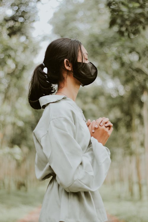 Woman with Face Mask Praying with Hands Clasped