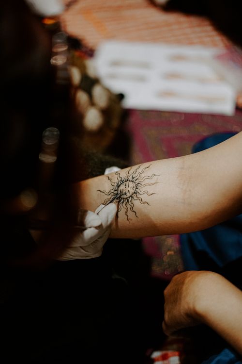 Free Detailed photo of a sun tattoo being inked on an arm, focusing on artistry. Stock Photo