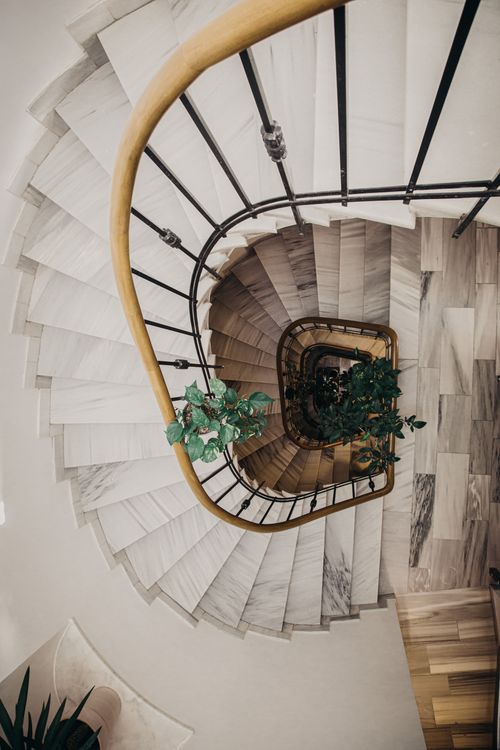 Free Stunning top view of a spiral staircase with an indoor plant at its center. Stock Photo