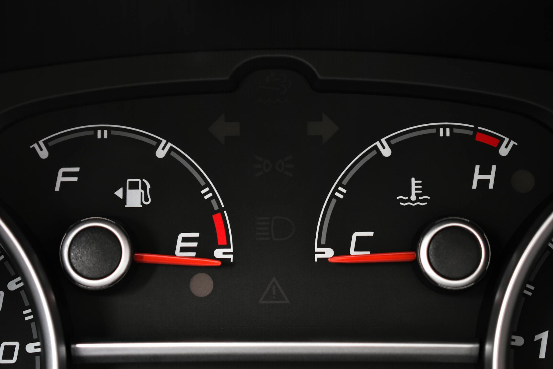 Detailed view of a car's fuel and temperature gauges on dashboard.