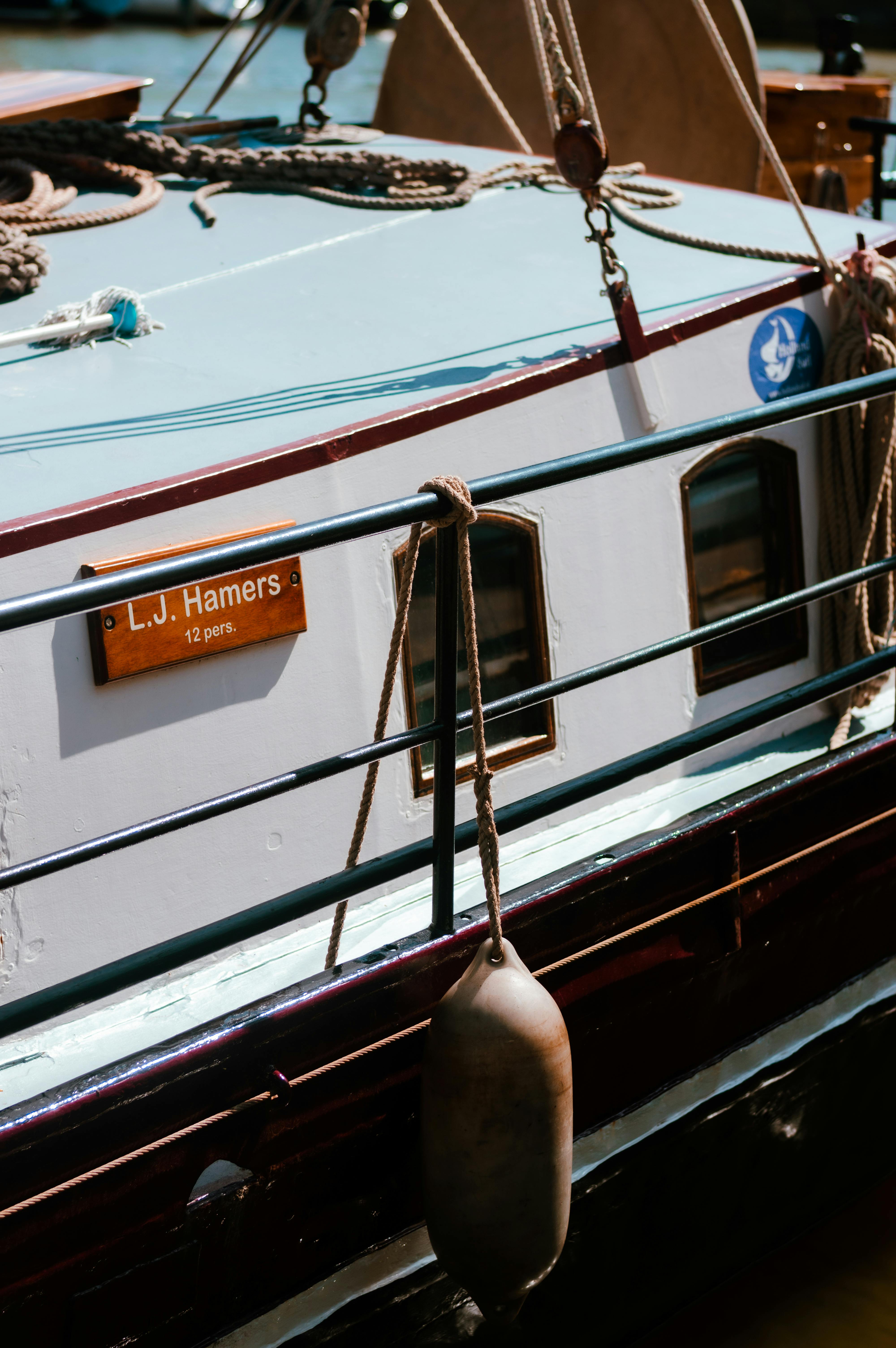 Detailed close-up of a vintage boat named L.J. Hamers on calm waters.