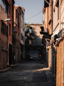 An empty urban alleyway between old buildings, showcasing architecture and shadow play.