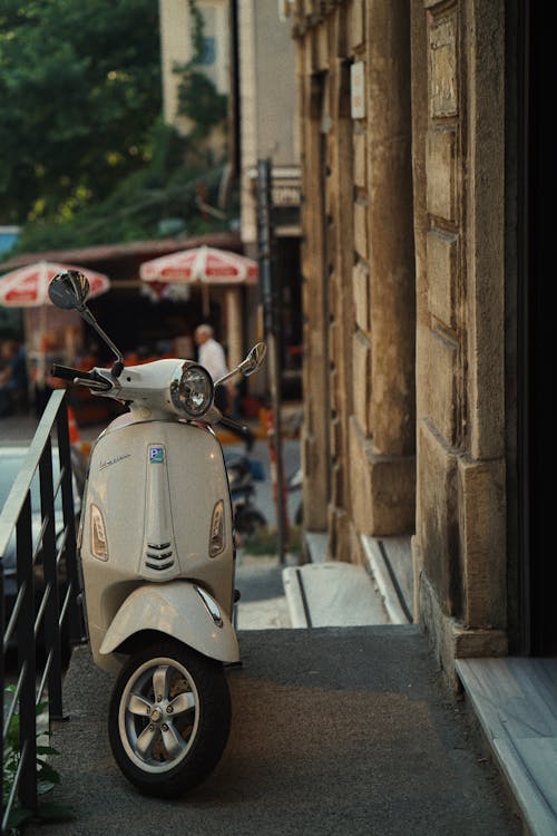 Beige Motor Scooter Parked Beside Brown Concrete Building