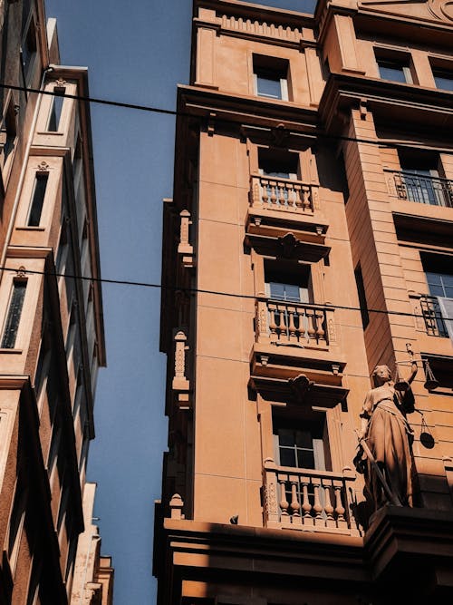 Brown Apartment Building Under Blue Sky