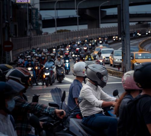 Free Congested urban road with motorcycles and cars amidst city infrastructure. Stock Photo
