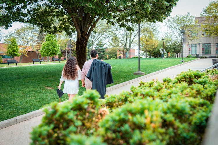 Couple Walking In Park After Graduation