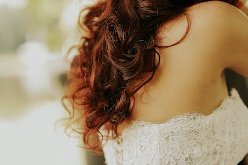 Woman With Long Wavy Hair in a White Lace Top