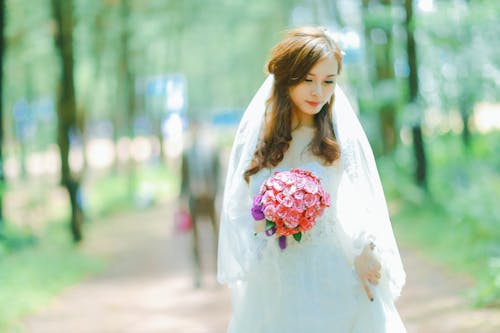 Beautiful Bride Wearing a Veil and White Dress Holding a Bouquet