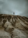 Person Standing on Rock Formation Under Cloudy Sky