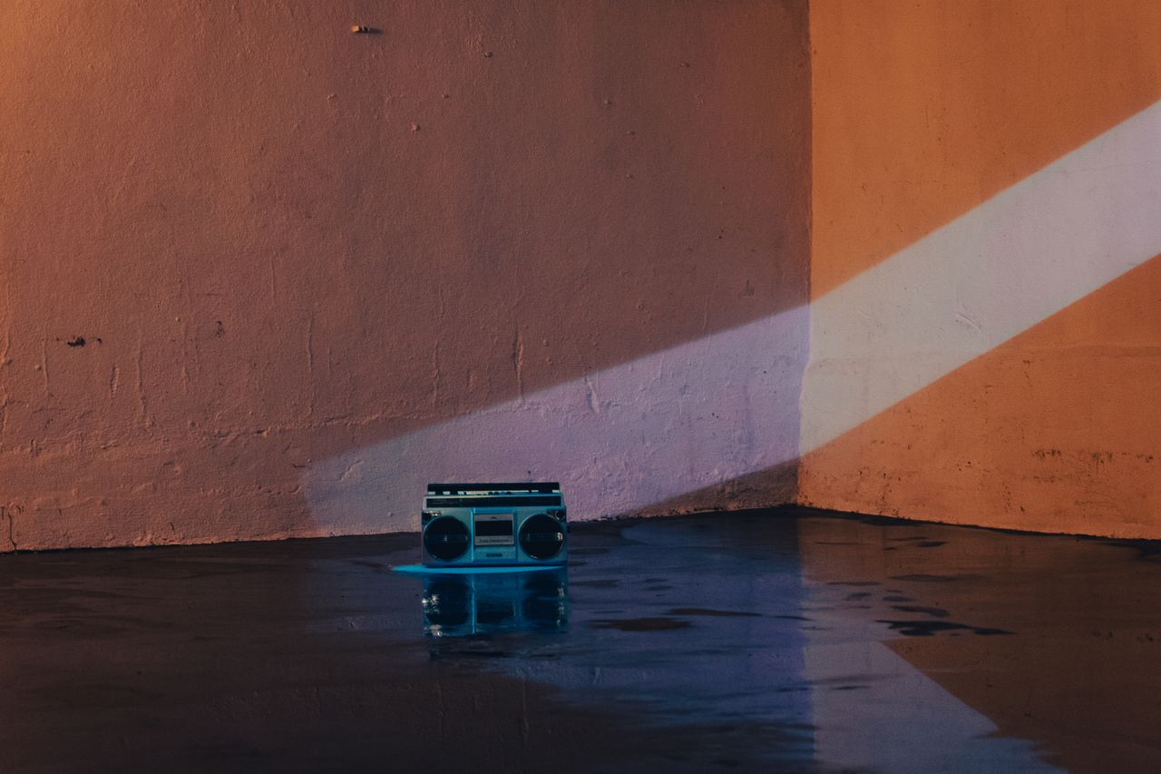 vintage boombox in a dimly lit room with wet floor reflections exuding