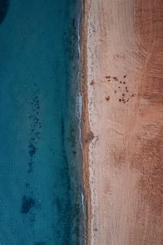 A stunning aerial view showcasing a pristine beach next to vibrant turquoise seawater, creating a natural contrast.