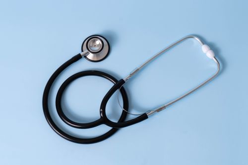 Free Medical stethoscope placed on a light blue surface, symbolizing healthcare and medical examination. Stock Photo