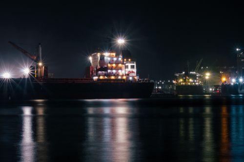 Free Illuminated ships docked at the port in Veracruz, Mexico, reflecting on calm waters at night. Stock Photo