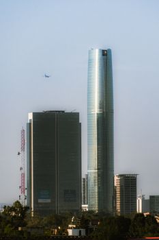 Skyline view with skyscrapers and an airplane in Santiago, Chile.