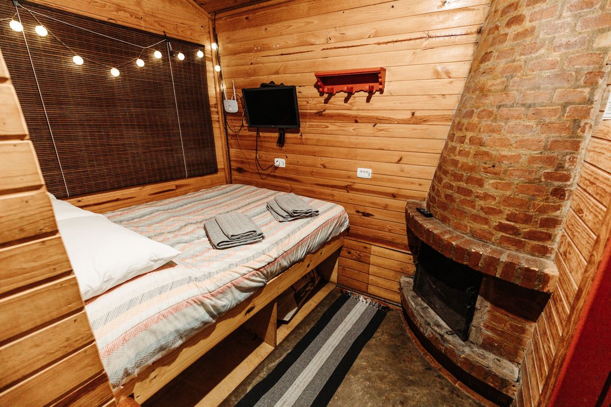 Wood-panelled bedroom with a brick fireplace, photo by Matheus Bertelli on Pexels