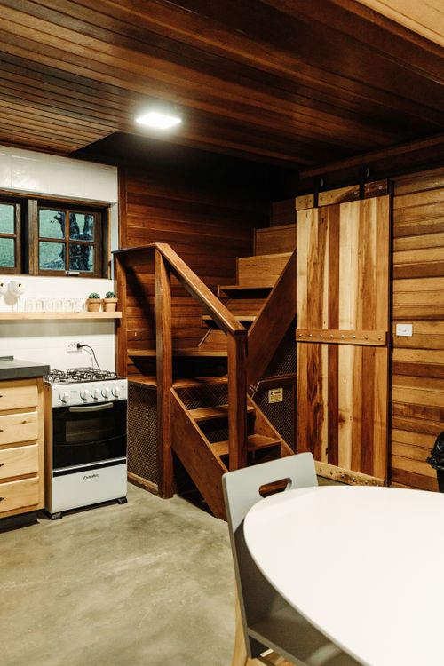 Free Warm and inviting wooden interior with rustic kitchen and staircase, offering a cozy atmosphere. Stock Photo
