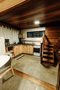 Warm and inviting wooden cabin kitchen with stairs, perfect for a cozy retreat.