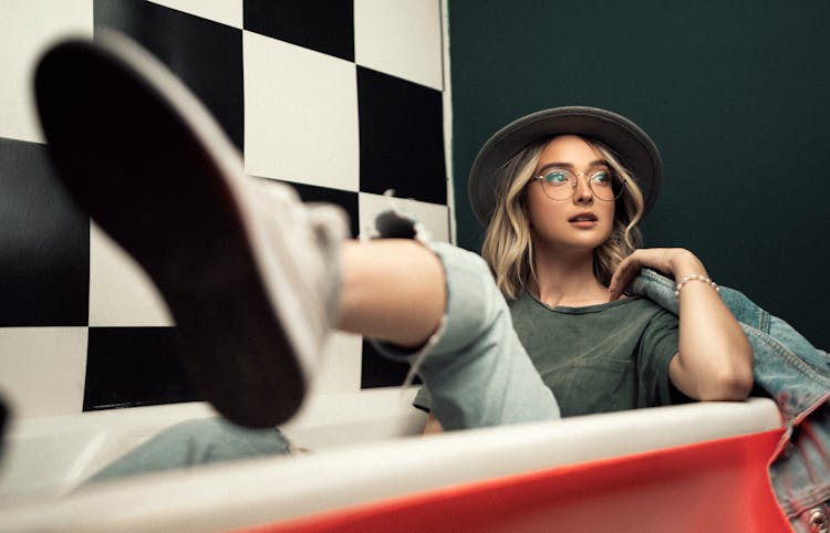 Woman Sitting In A Bathtub Fully Clothed