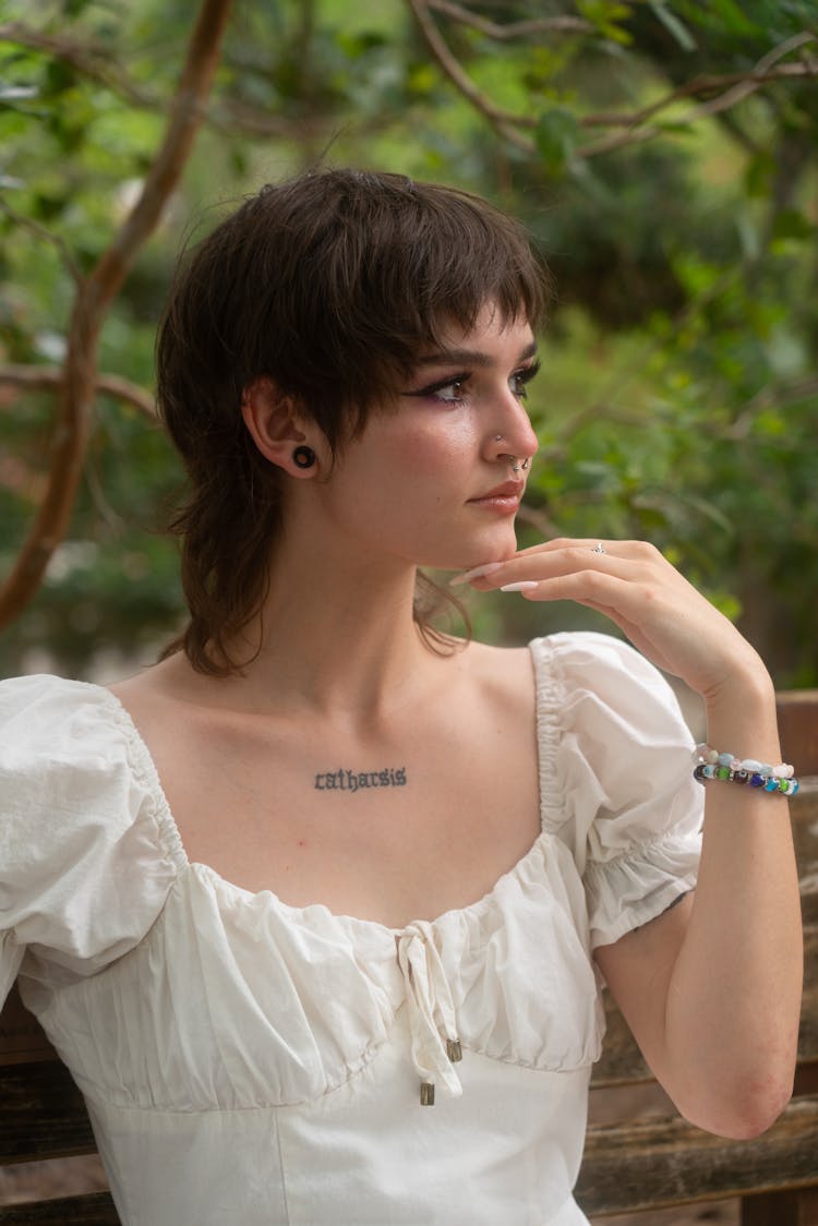 Woman With A Chest Tattoo Wearing A White Blouse 