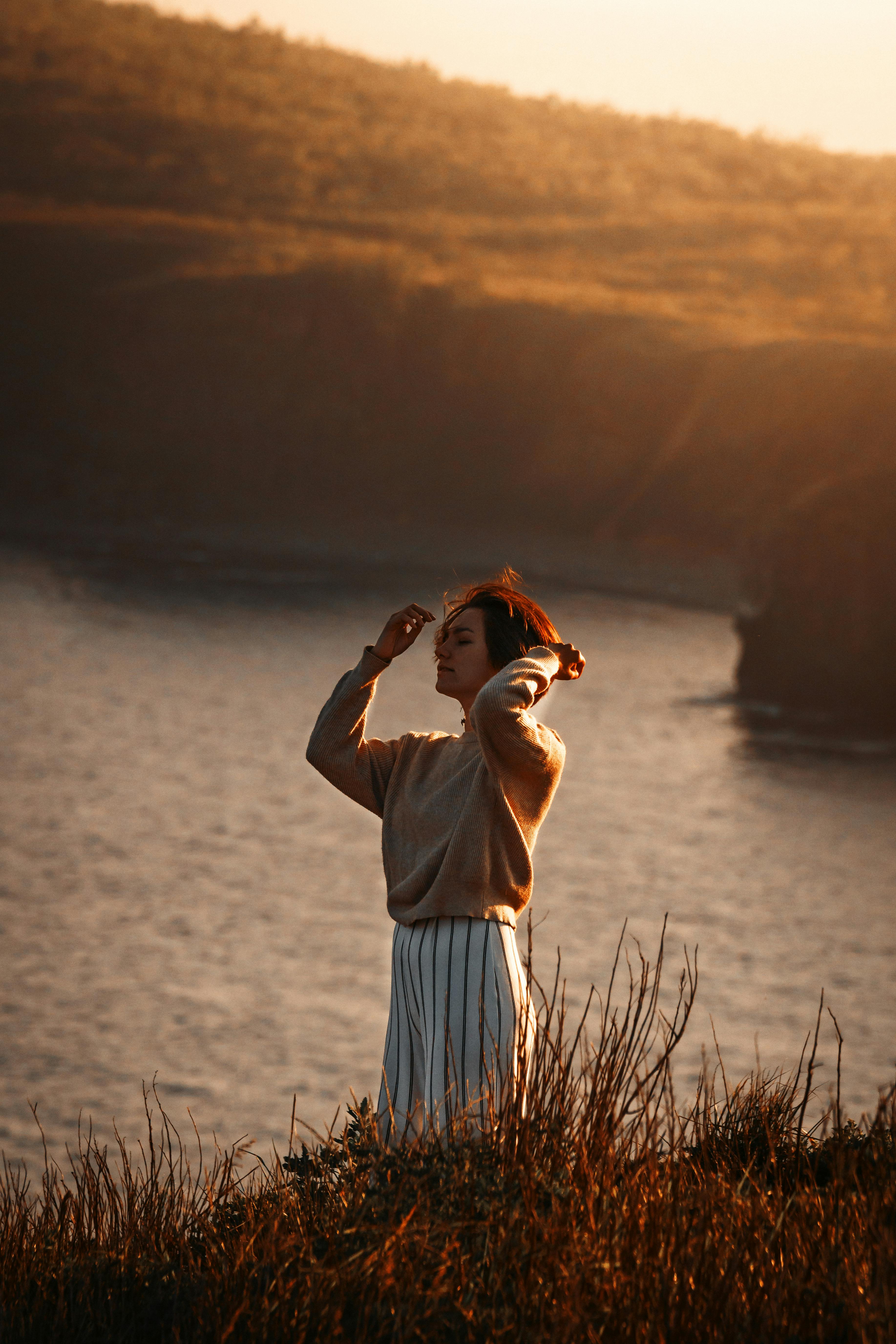 Young woman enjoying a tranquil sunset by the sea in Primorsky Krai, Russia.