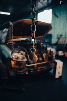Close-up of a chain hook inside an industrial car workshop in São Paulo, Brazil.