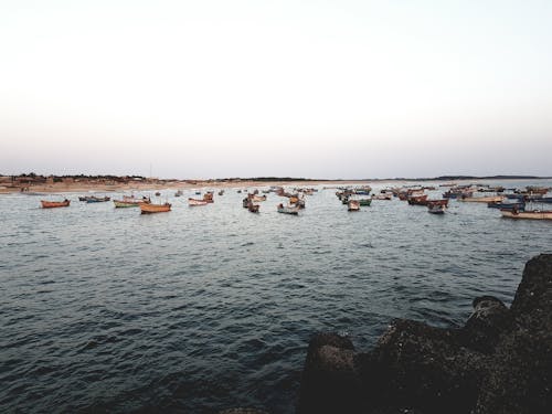 Boats Floating on the Sea Under White Sky