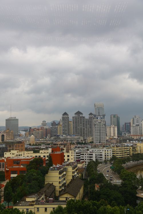 Free Aerial view of a cityscape with skyscrapers under a dramatic cloudy sky. Stock Photo