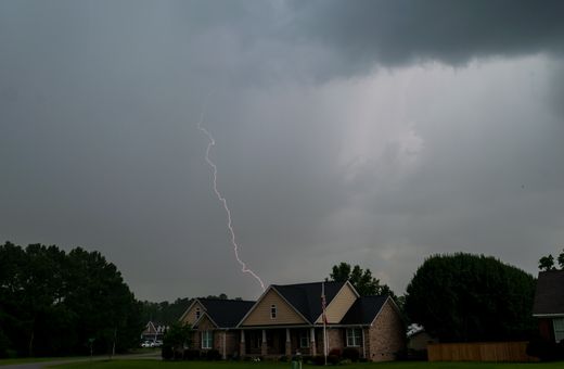 Lightning striking over suburban houses