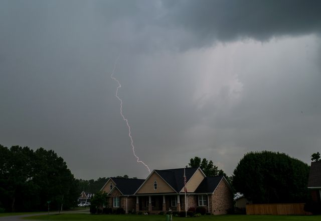 Lightning striking over suburban houses