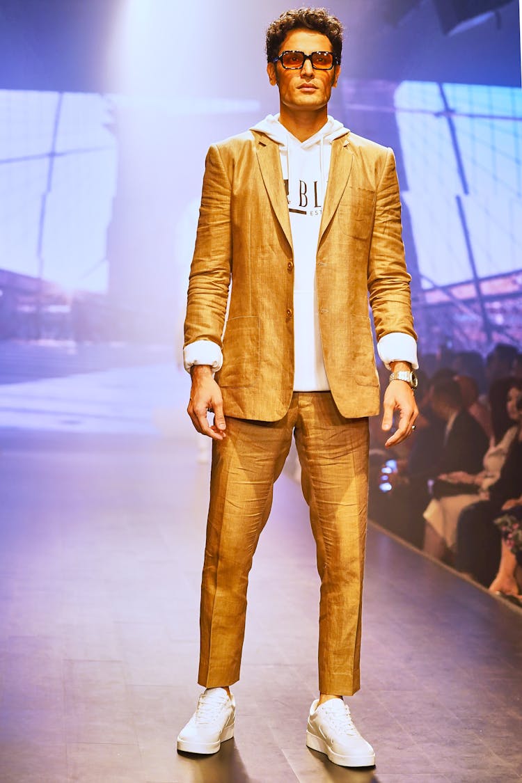 Male Model Wearing Brown Suit And Pants While Standing On A Runway