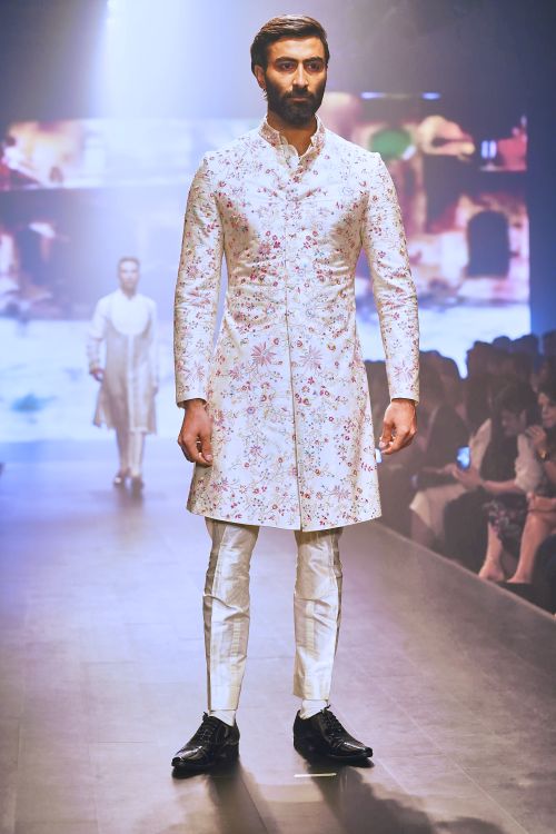 Free Stylish male model showcasing a floral kurta at a fashion runway event. Stock Photo
