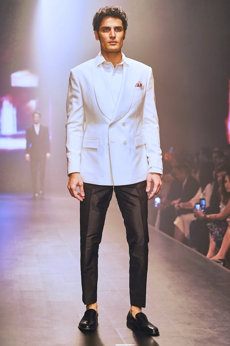 Man In White Suit Jacket Standing On Catwalk