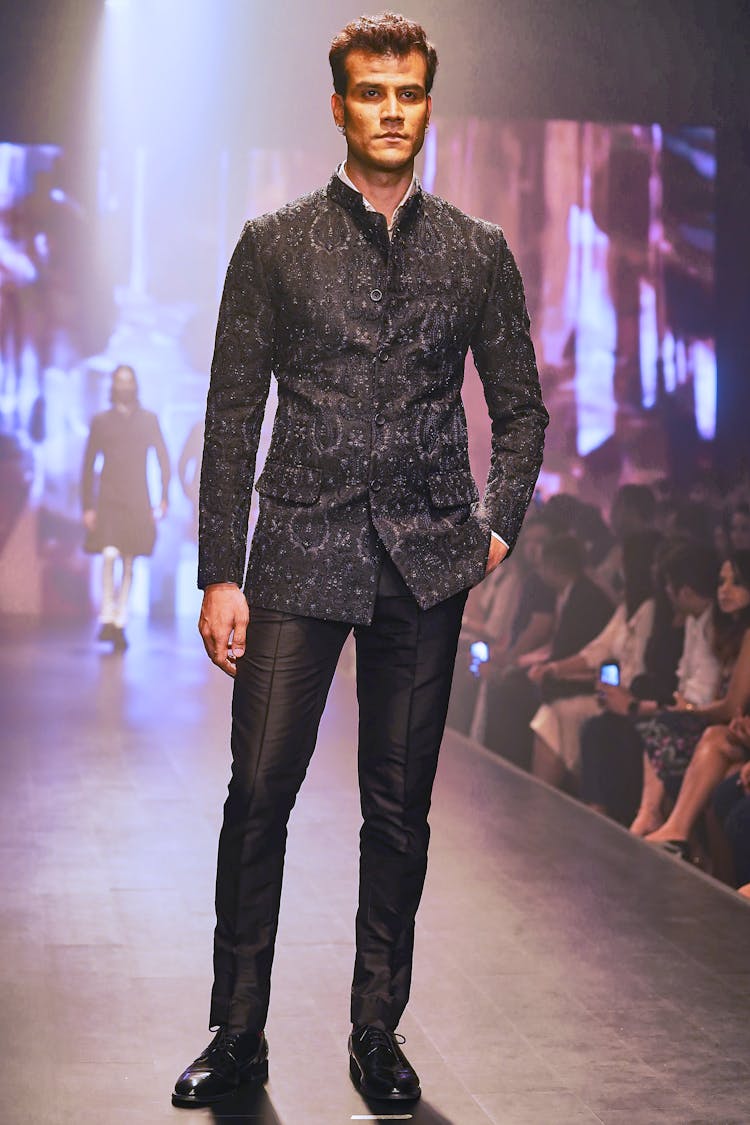 A Model In A Black Outfit On A Runway