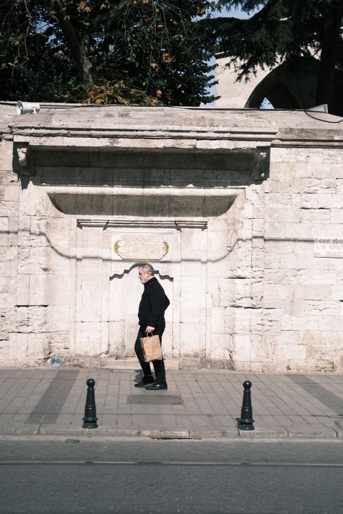 Free An elderly man walks with a paper bag along a historic street in Istanbul, Turkey. Stock Photo