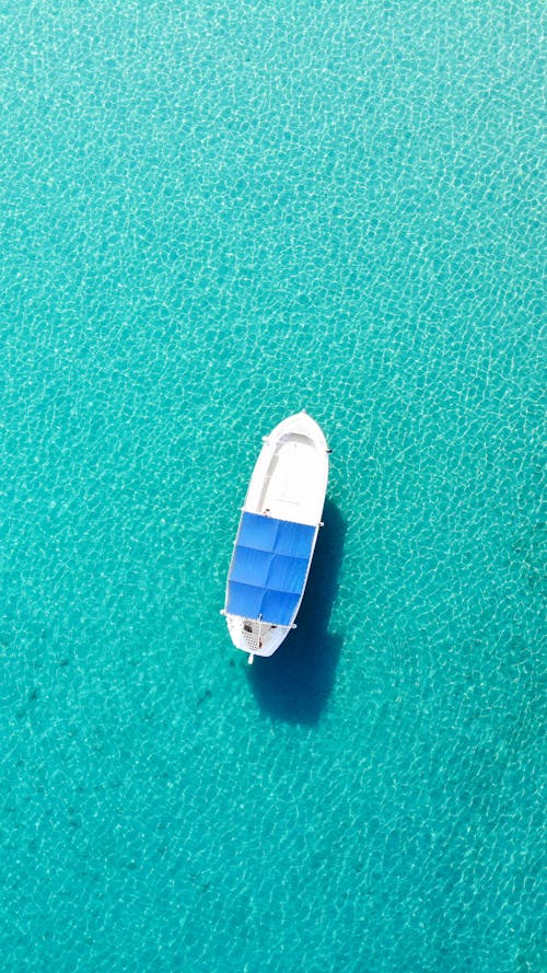 A White and Blue Boat on Turquoise Water