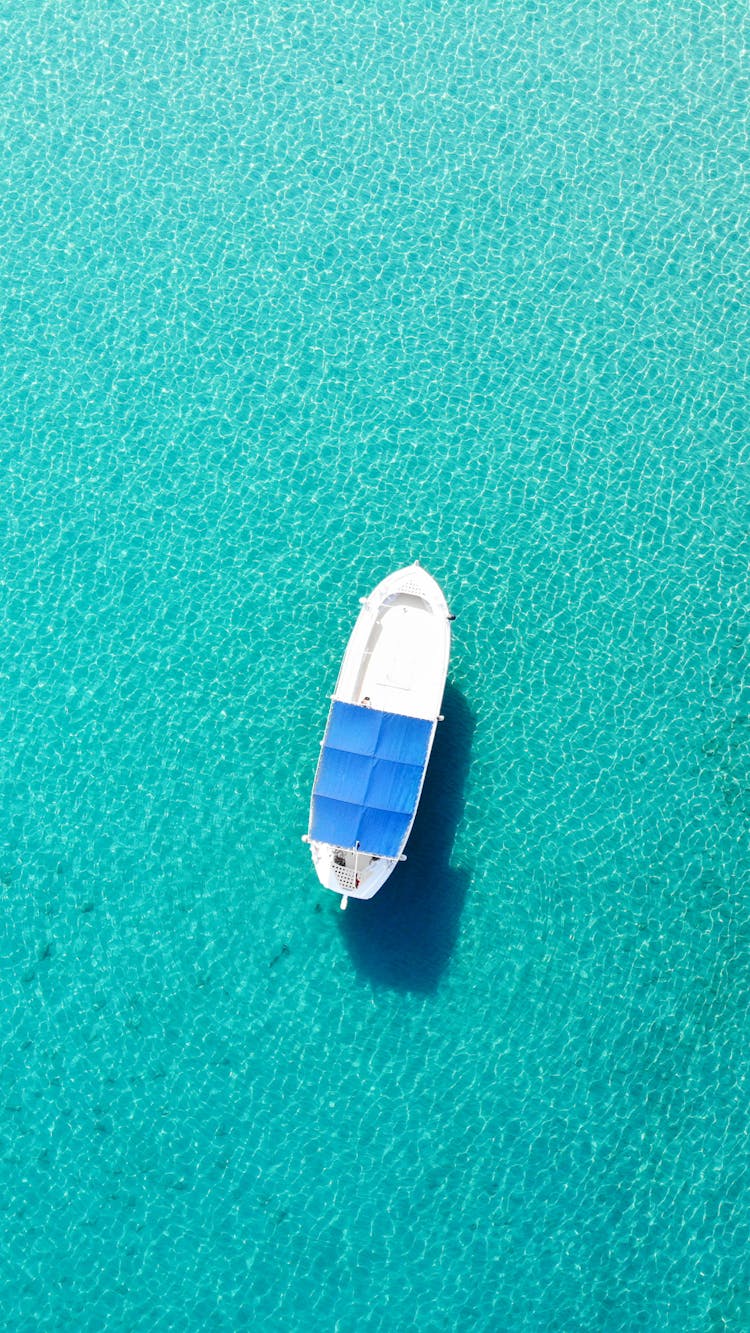 A White And Blue Boat On Turquoise Water