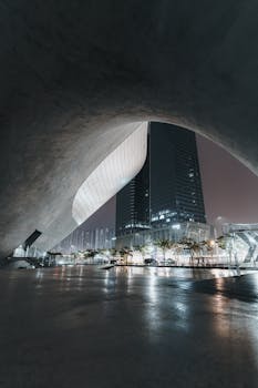 Stunning view of modern architecture framing a brightly illuminated cityscape, perfect for urban exploration themes.