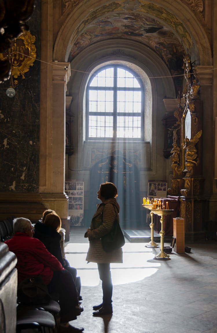 People Inside A Church With Arched Glass Window