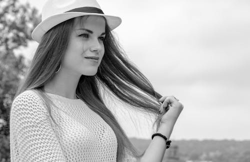 Free A Woman With Long Hair Wearing a Hat Stock Photo