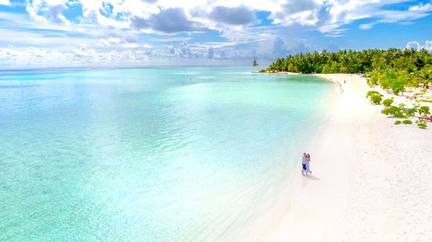 Couple enjoying a romantic moment on a pristine tropical beach in the Maldives.