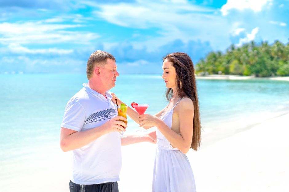 A couple enjoys drinks at a tropical beach, capturing a moment of romance and relaxation. - Barbados Nightlife for Couples: Romantic Bars and Sunset Cruises