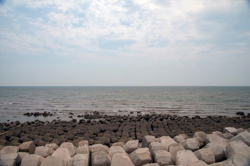 Free Tranquil ocean view with geometric rocks under a clear sky. Stock Photo