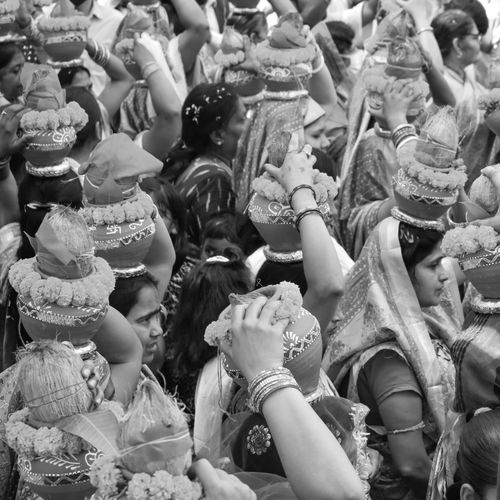 Free Women in traditional attire carrying decorated pots in a cultural procession. Stock Photo