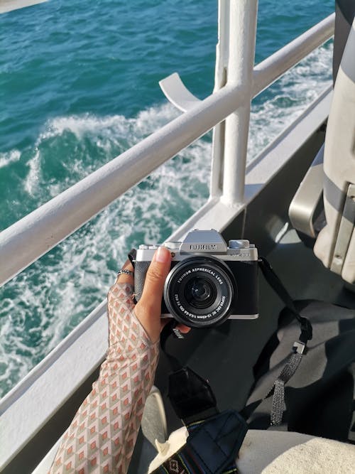 A Person in a Ferry Holding a Fujifilm Camera