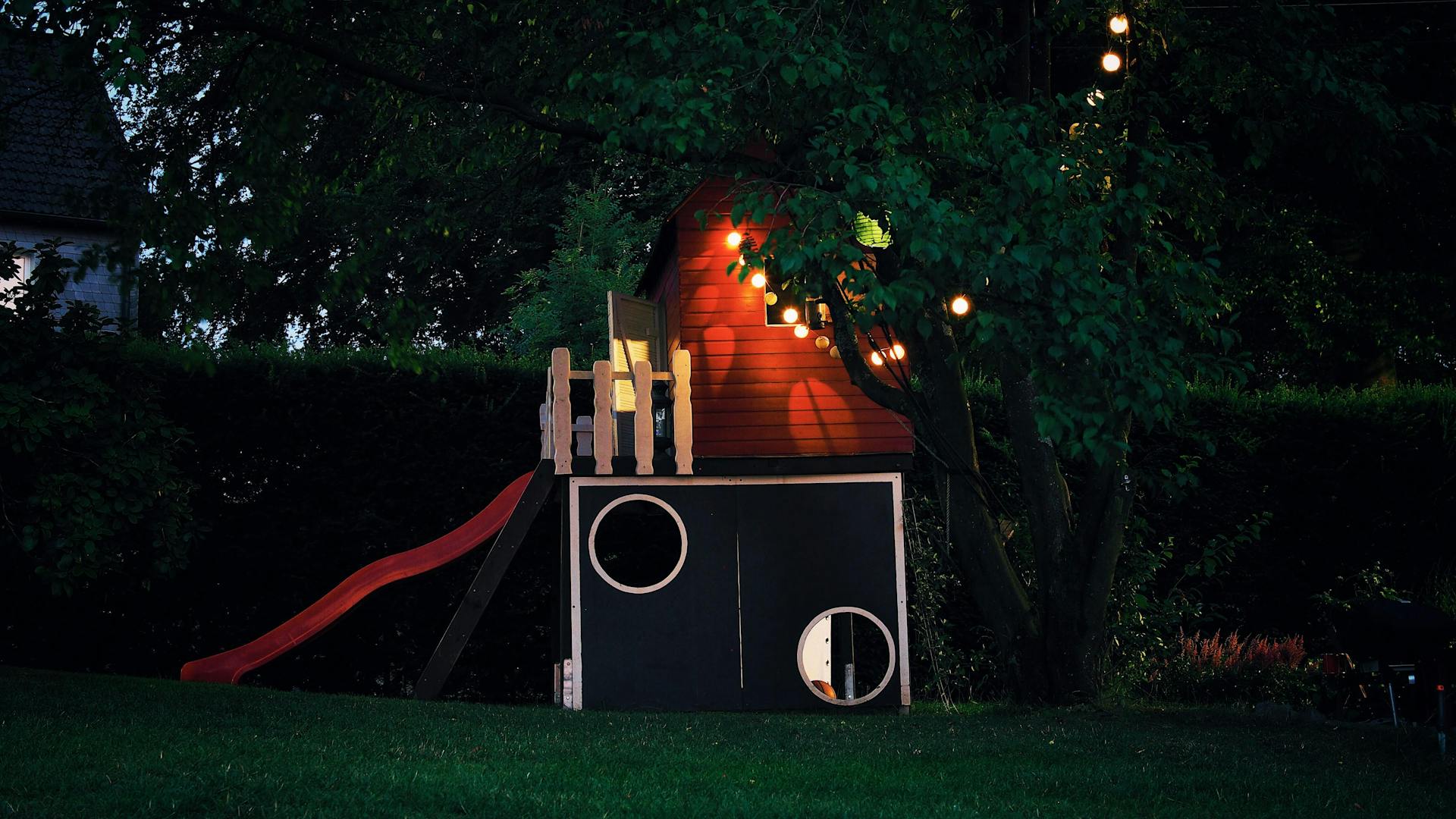Boomhut verlicht met sfeerverlichting in de tuin — Woodz Design